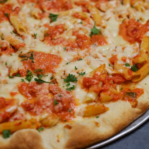 Close-up of a Sorella's Pizza & Pasta pizza topped with penne pasta, red sauce, and melted cheese.