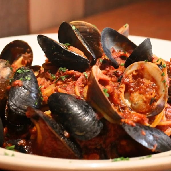 Sorella's linguine with clams and mussels in a rich red sauce, garnished with fresh parsley.